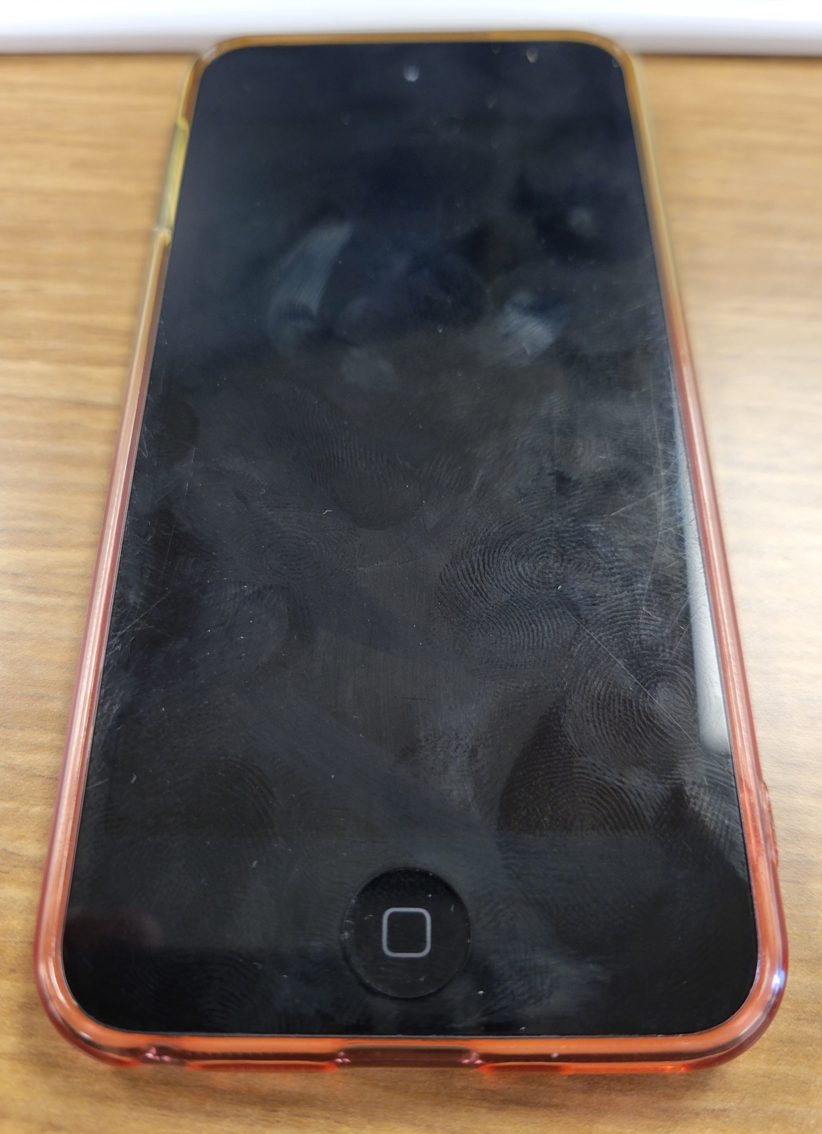 The front screen of a 7th-generation iPod Touch. The edge of an orange-yellow gradient clear case can be seen on the sides.