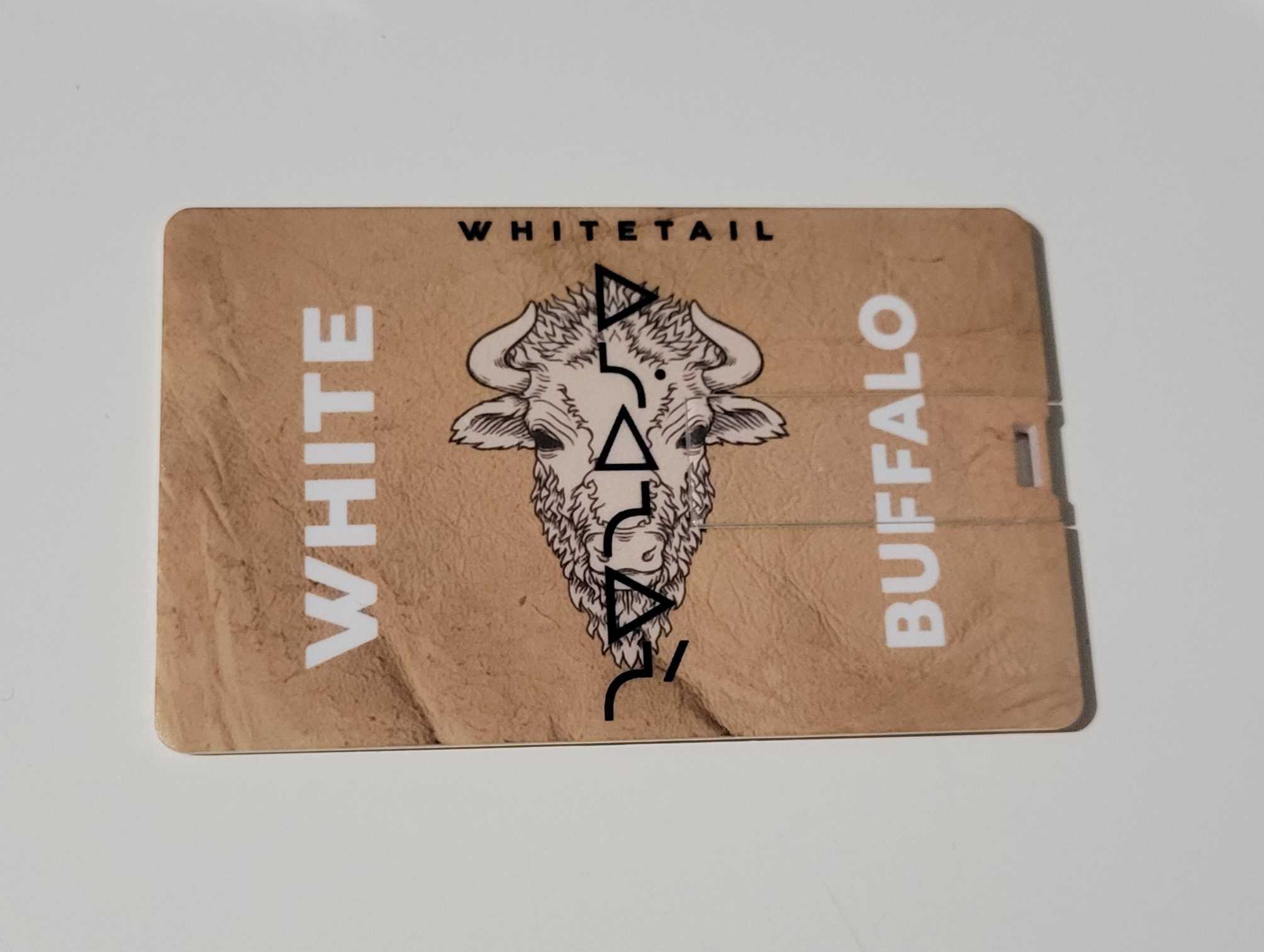 A light tan card with the words WHITE on the left, and BUFFAO on the right, with WHITETAIL at the top centre. There is a stylized picture of a buffalo in the centre with Cree writing placed vertically above it.